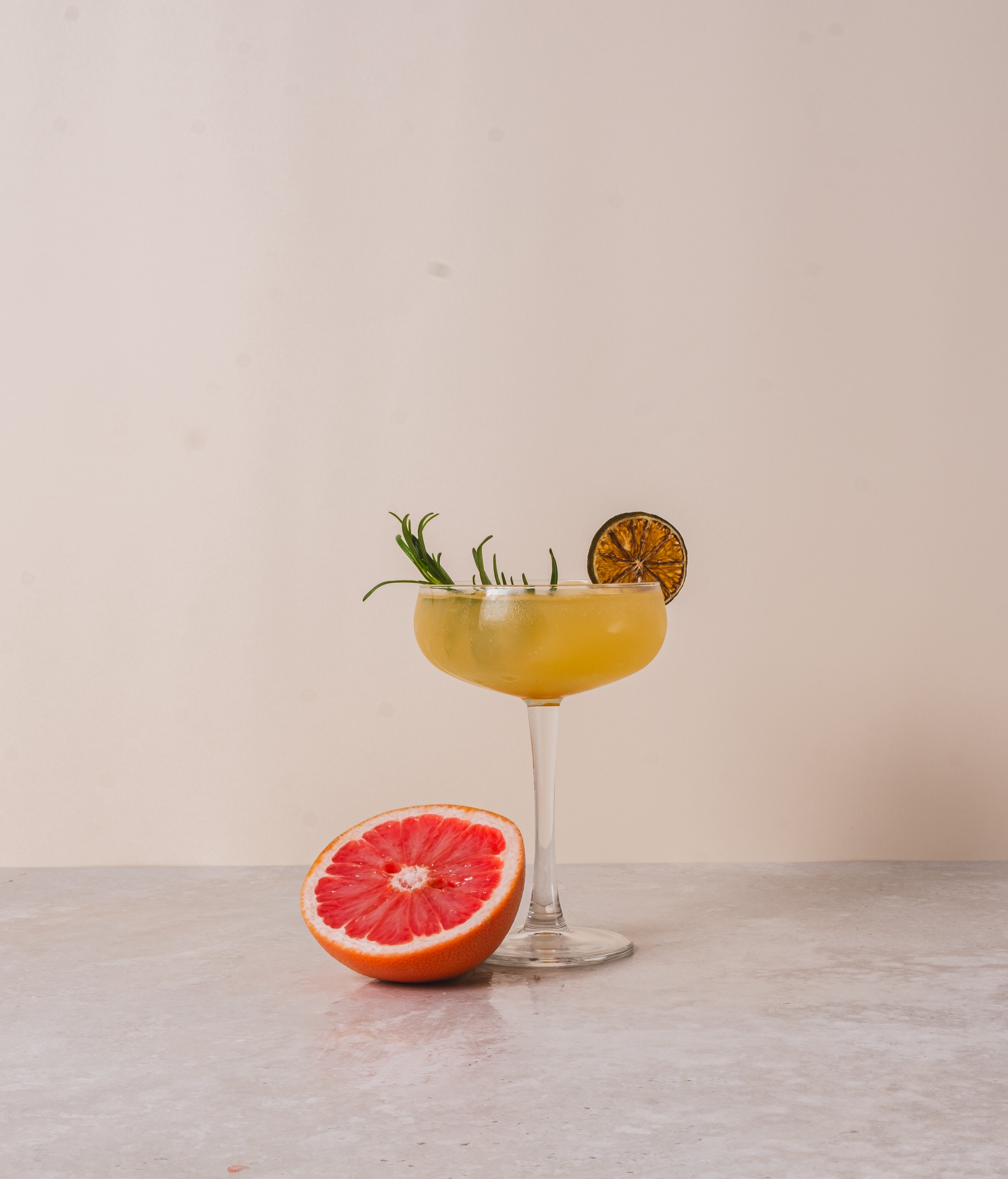 Hoog glas met een mocktail gemaakt met BOHO bloedappelsien rozemarijn siroop – frisse citrus en kruidige rozemarijnsmaak