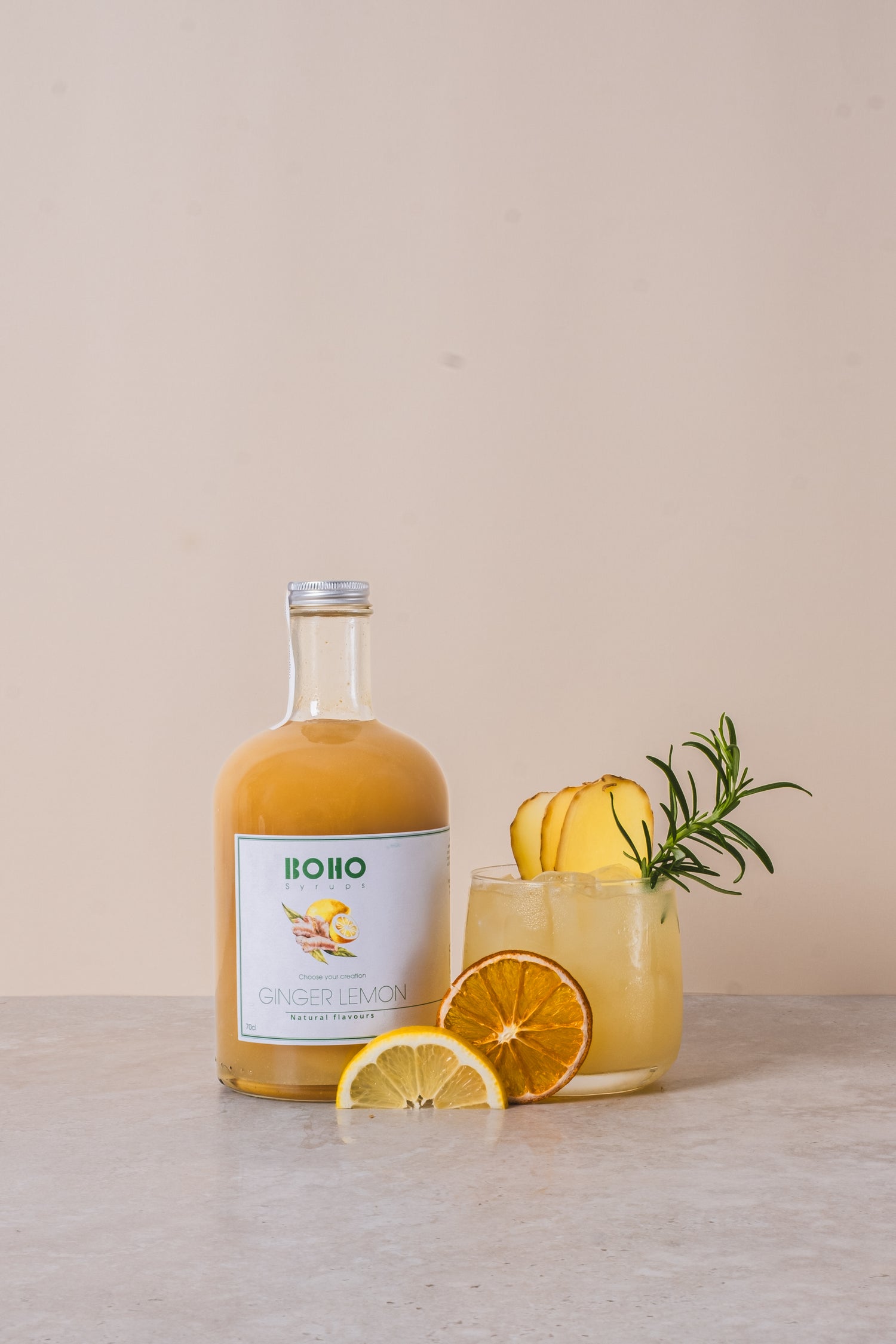 Fles BOHO gember citroen siroop met een homemade gember citroen limonade ernaast – frisse en pittige dorstlesser