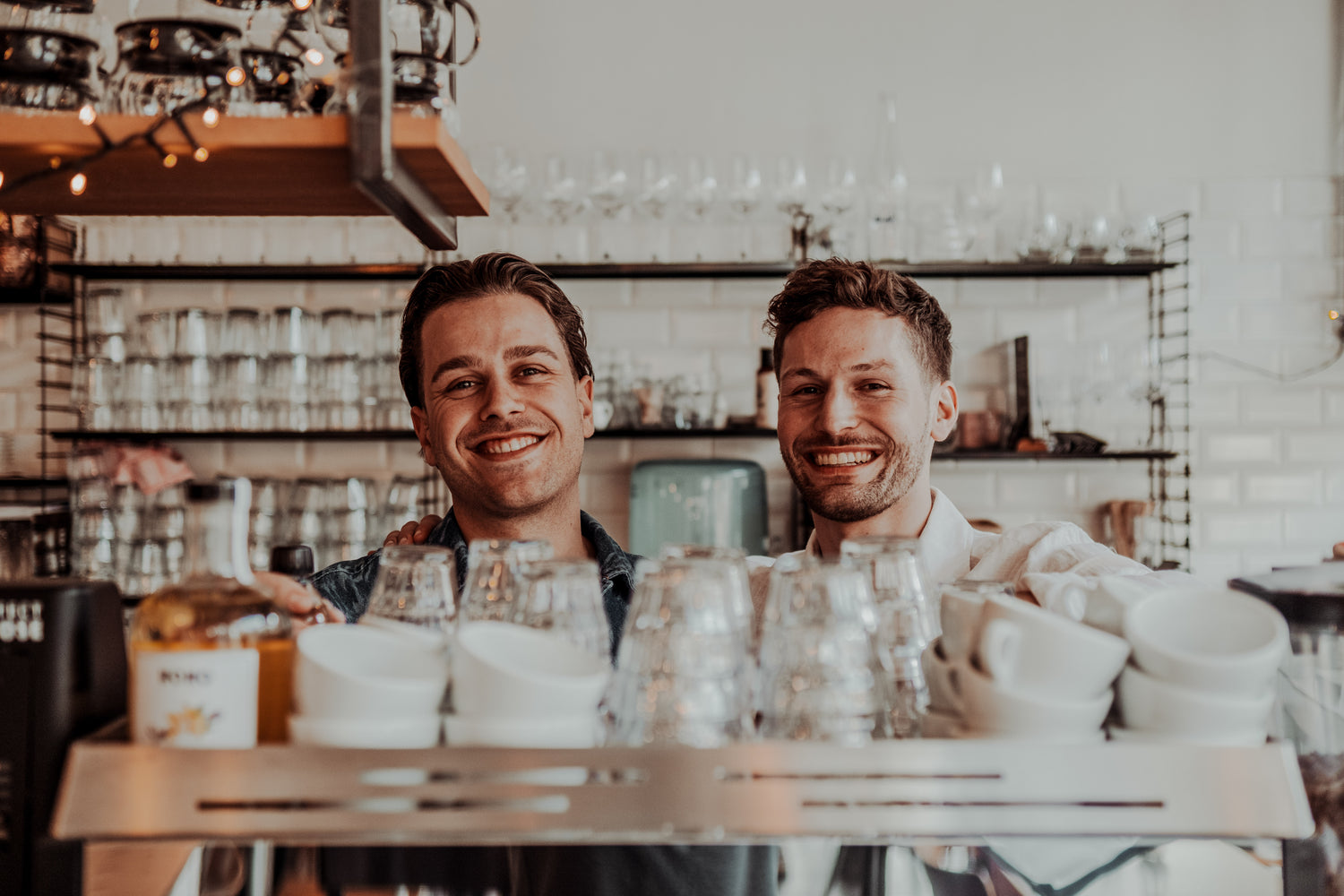 Joeri en Jef van BOHO Syrups lachen samen boven het koffieapparaat – authentieke en vrolijke sfeer