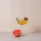 Hoog glas met een mocktail gemaakt met BOHO bloedappelsien rozemarijn siroop – frisse citrus en kruidige rozemarijnsmaak
