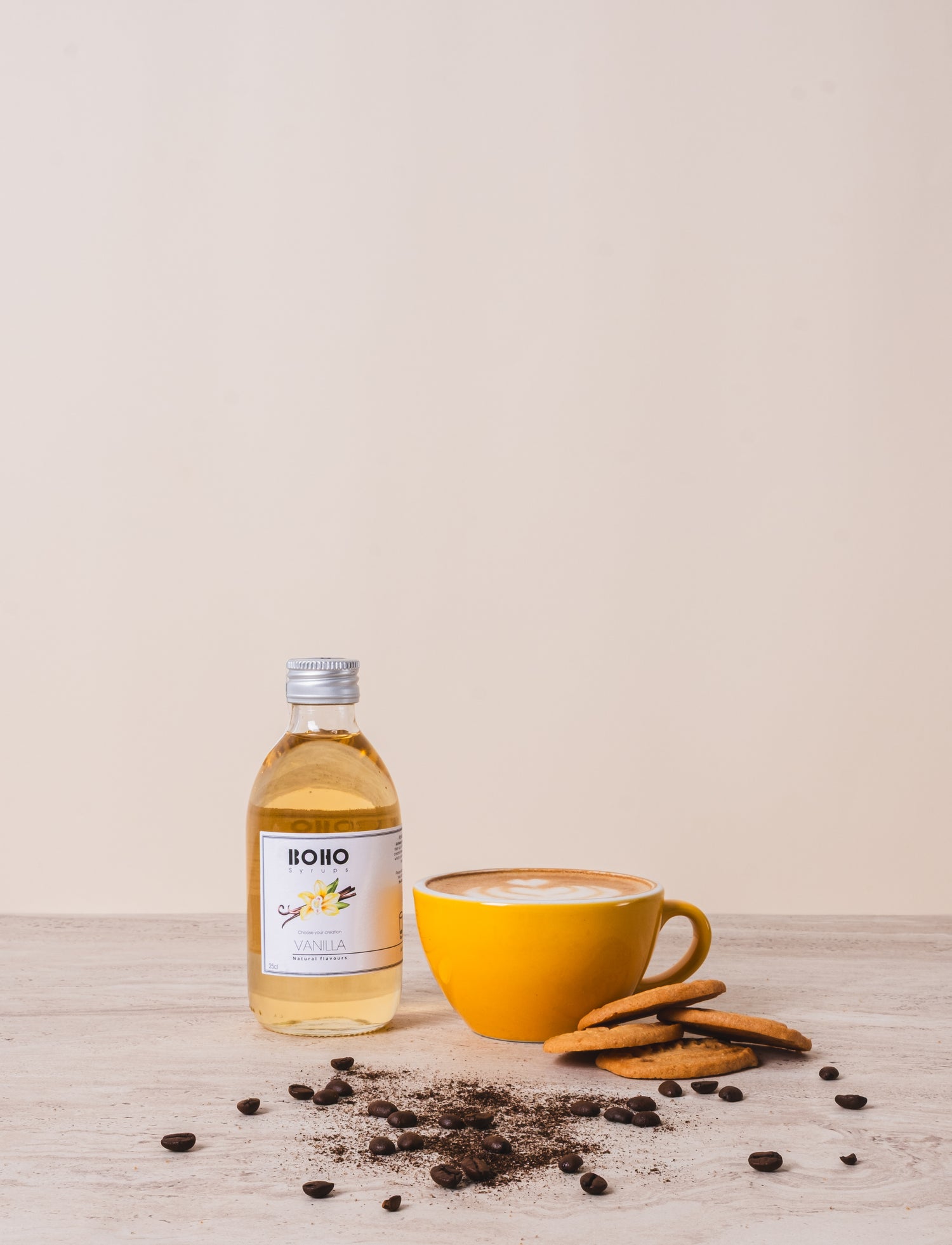 Flesje BOHO vanille siroop naast een cappuccino – zachte en romige koffiesmaak met vanilletoets